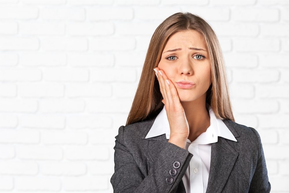 girl with toothache - 5 signs that you need to see a dentist